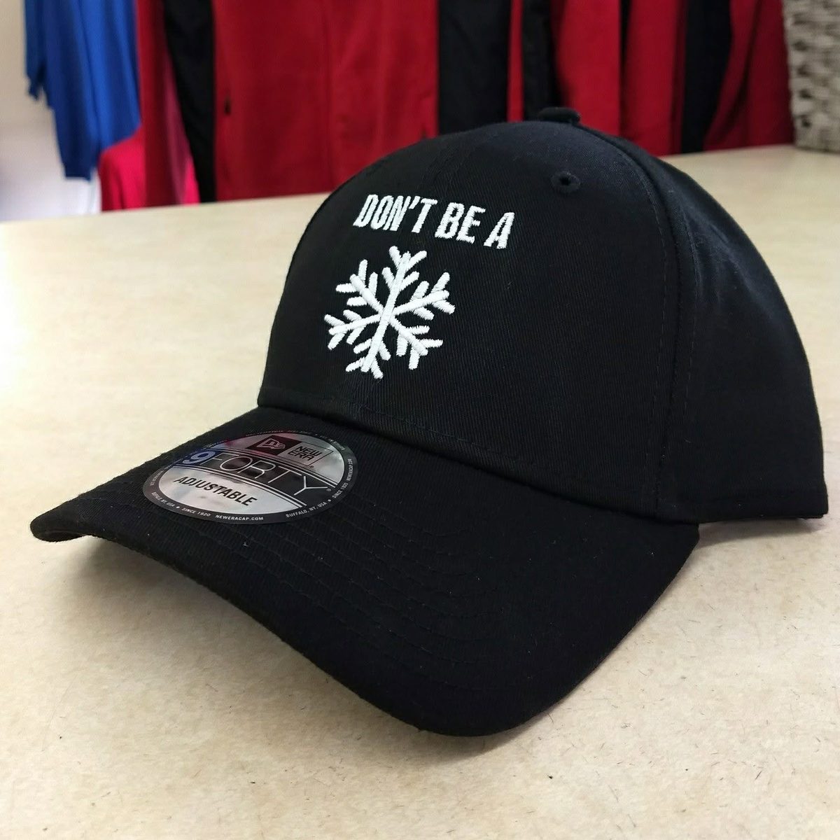 Black baseball cap with a white snowflake and the words Don&rsquo;t Be A