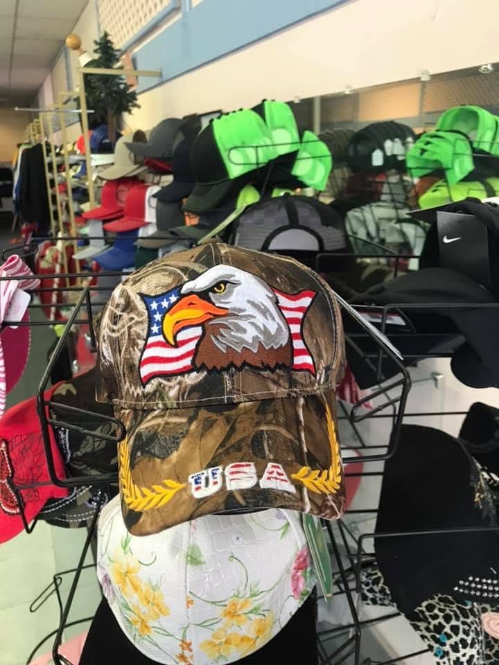 Cap display topped by a cap embroidered with a bald eagle and an American flag